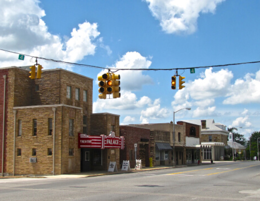 an empty street with a stop light hanging over the road