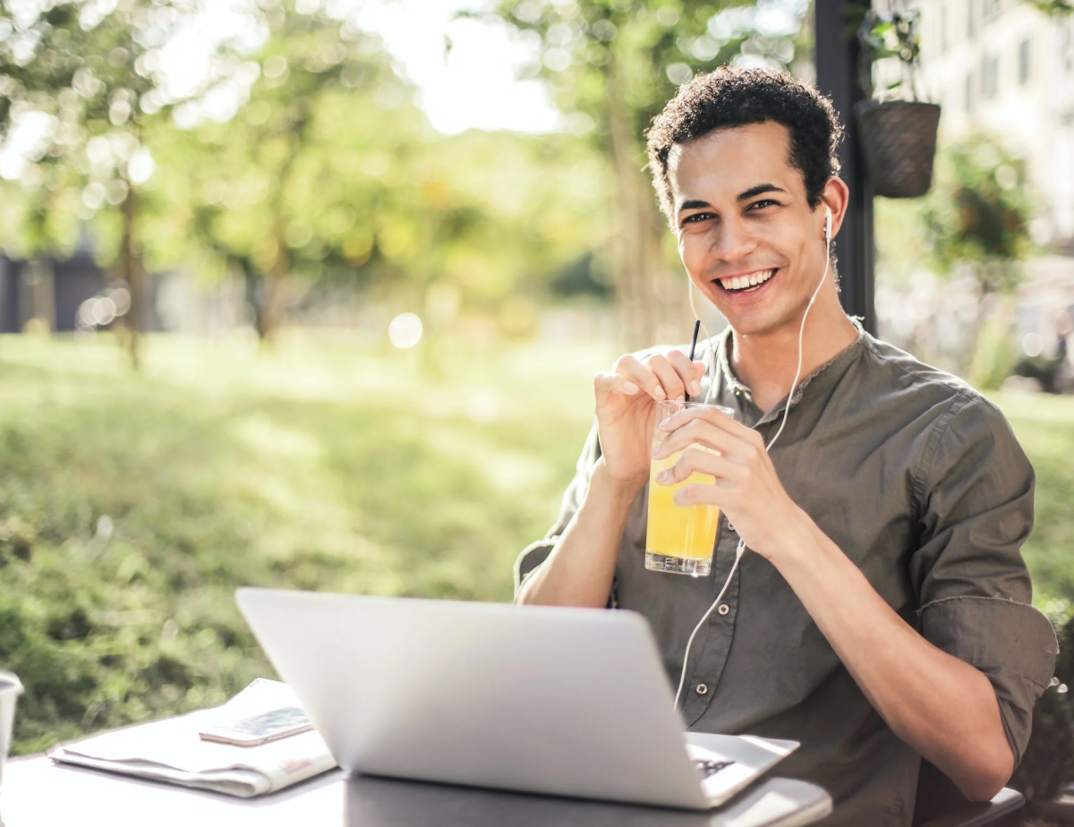 person drinking lemonade while on a laptop