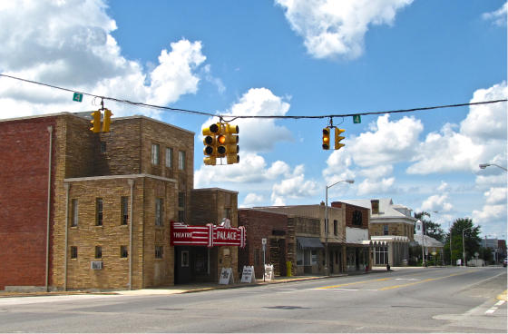 an empty street with a stop light hanging over the road