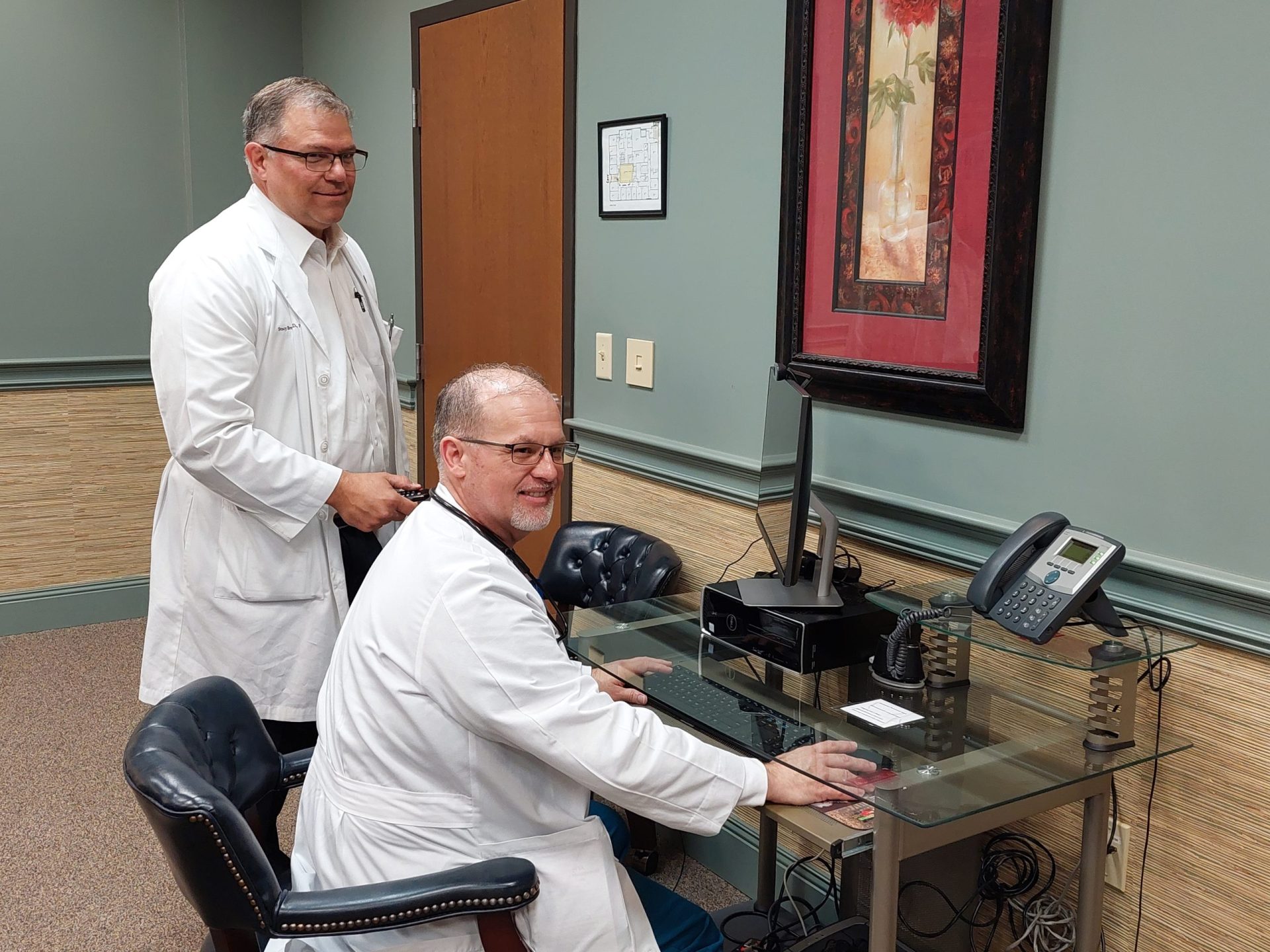 Photo: Dr. Stacy Brewington, standing, a cardiologist at Tennessee Heart, and Sean Smithey, an acute care nurse practitioner specializing in heart failure at Tennessee Heart, discuss a patient’s care.