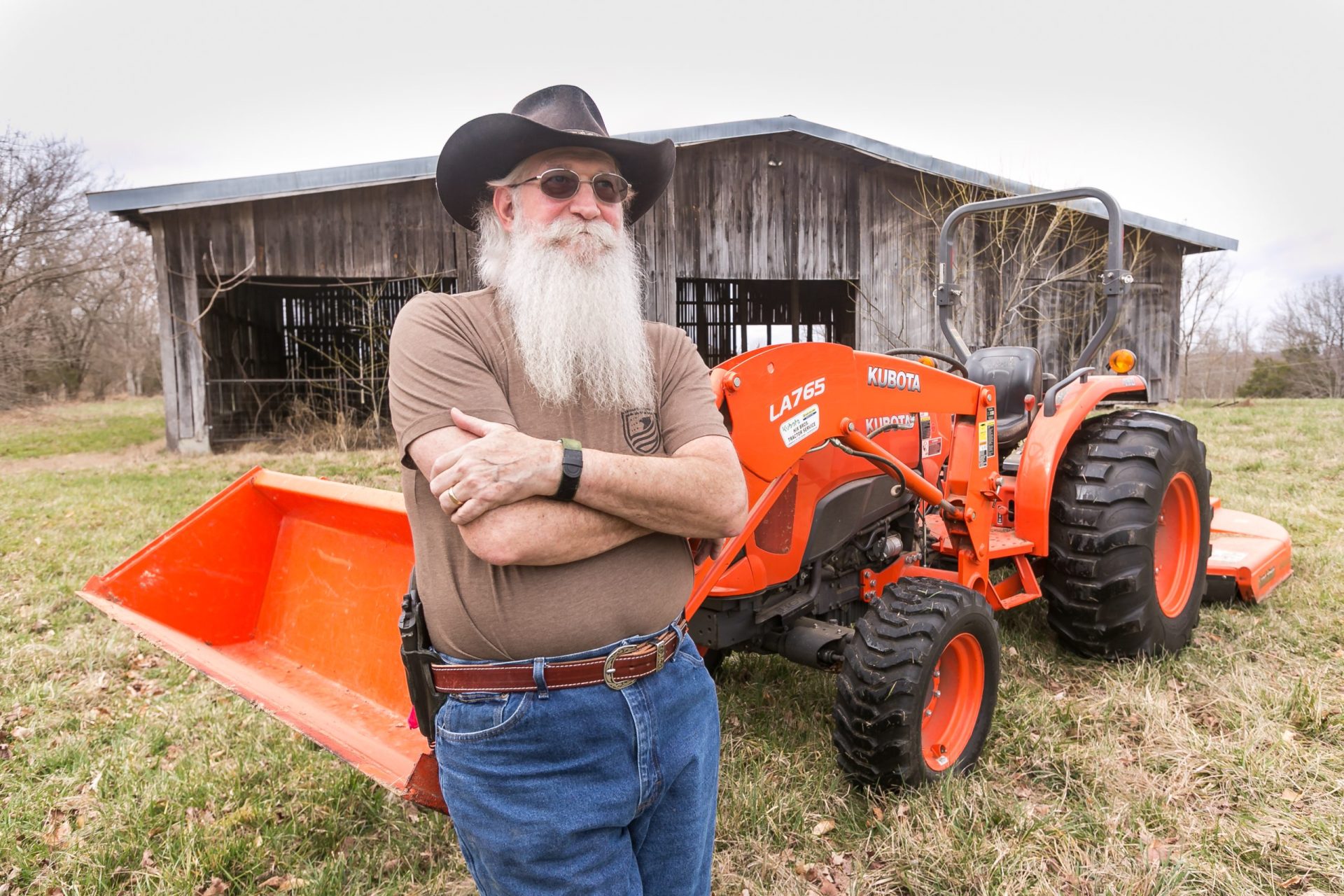 Larry Pearson outside leaning on tractor.