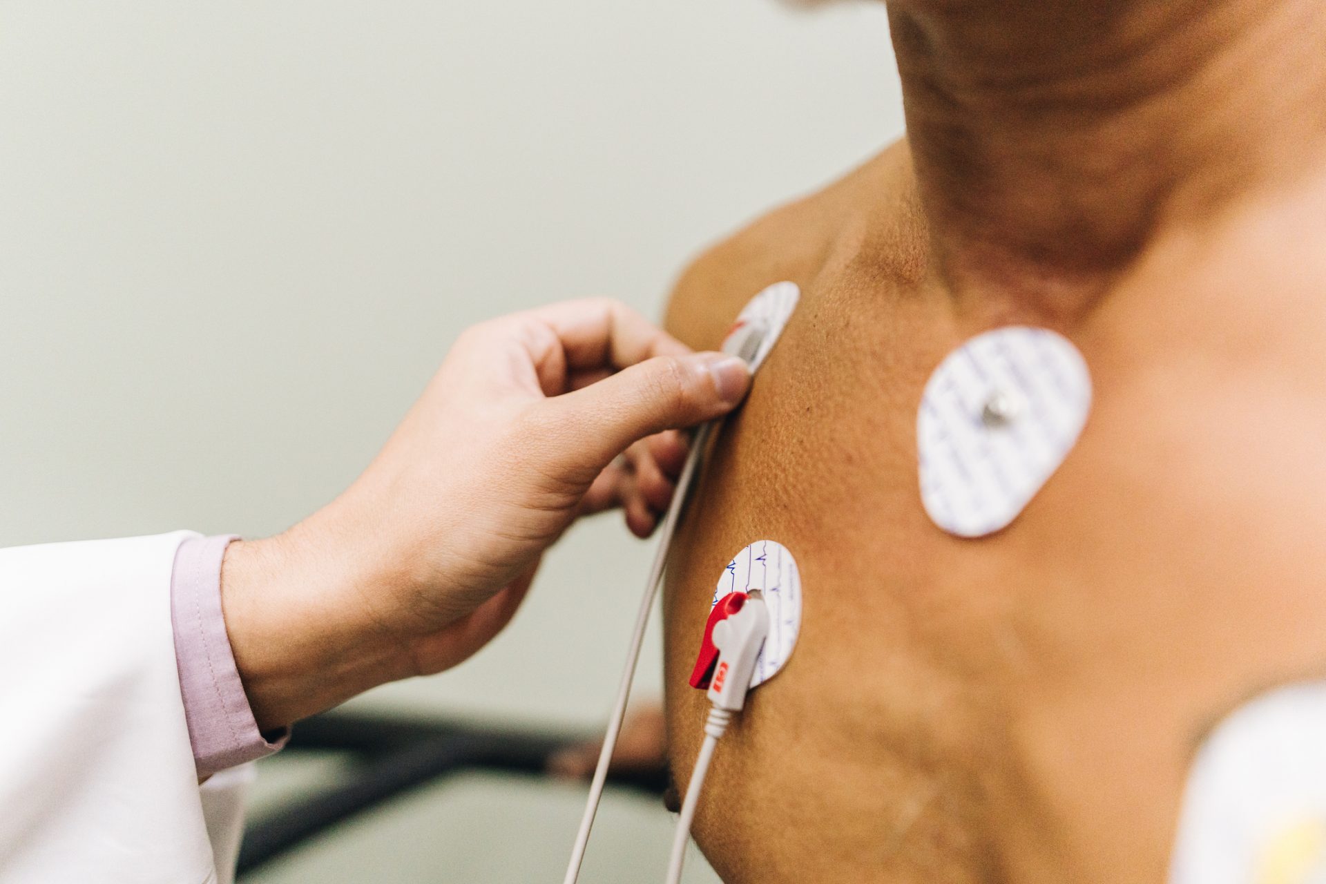 Close-up of doctor hands putting sensors of electrocardiography on a doctor's office